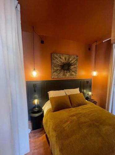 une chambre avec un lit avec un mur orange dans l'établissement Description Maryse Bastié, à Lyon