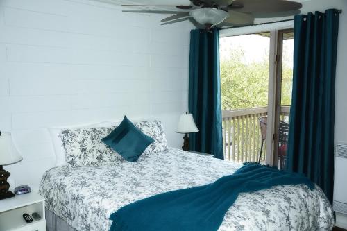 a bedroom with a bed with a ceiling fan and a window at Condos Memphrémagog in Magog-Orford