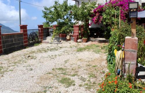 a yard with a fence and some flowers at Villa Maria - Sant'Angelo di Brolo in SantʼAngelo di Brolo