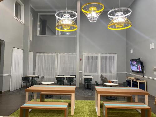 a room with tables and chairs and lights at Spark By Hilton Galveston in Galveston