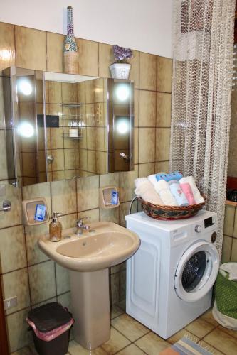 a bathroom with a washing machine and a sink at Villa Maria - Sant'Angelo di Brolo in SantʼAngelo di Brolo