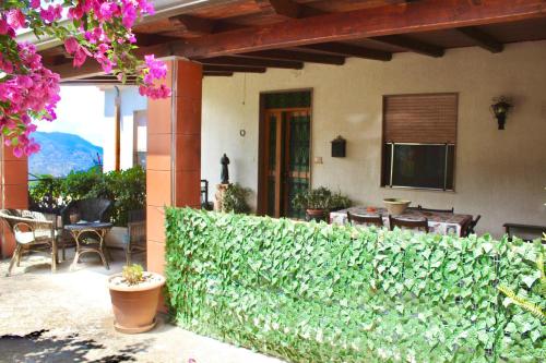a house with a green hedge in front of a patio at Villa Maria - Sant'Angelo di Brolo in SantʼAngelo di Brolo