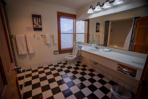 a bathroom with a sink and a toilet and a mirror at Nuk's Executive Suites in De Pere