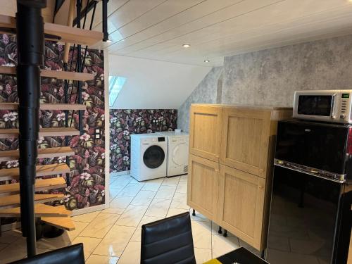 a kitchen with a microwave and a washer and dryer at La Petalerie in Épernay