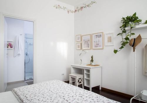 a white bedroom with a bed and a desk at la foglia verde in Pesaro