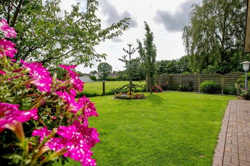 a garden with pink flowers on the grass at Ferienwohnung 'Ferien bei Buske' in Tellingstedt