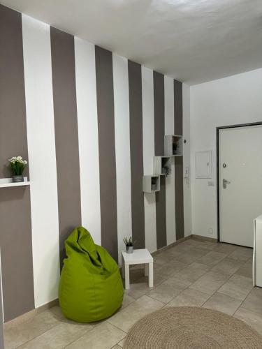 a room with a green ottoman and a striped wall at Bon Bon San Martino in Asti