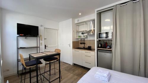 une petite pièce avec une table et une cuisine dans l'établissement Nestor - Studio rénové Vieux Lille Esplanade -, à Lille