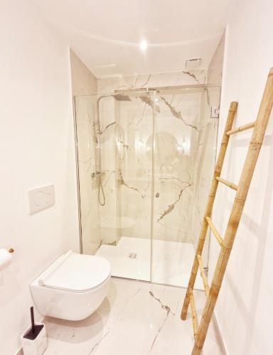 une salle de bain blanche avec douche et toilettes dans l'établissement Maison Juliette, à Clichy