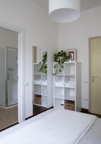 a bedroom with white shelves and a white bed at la foglia verde in Pesaro