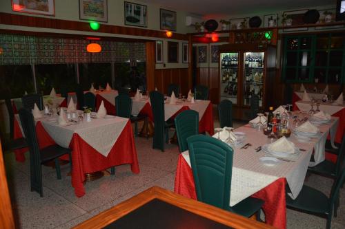 a dining room with tables and chairs with red and white table settings at Manuela Residence in Lagos