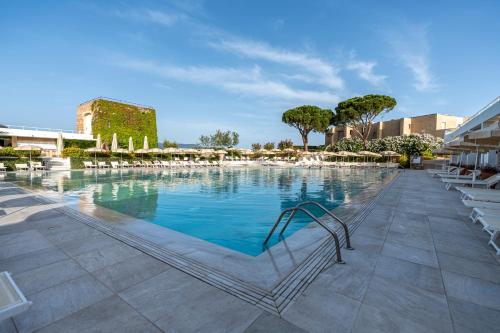 a large swimming pool with lounge chairs in a resort at Mangia's Pollina Resort in Cefal&ugrave;