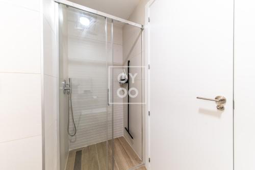 une douche avec une porte vitrée dans une salle de bain dans l'établissement FineFleur Finestrat - see and mountain views - by OYOOSTAYS, à Finestrat