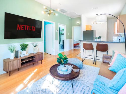 a living room with a tv on a wall at Traveler's Dream - Free Parking near Forsyth Park in Savannah