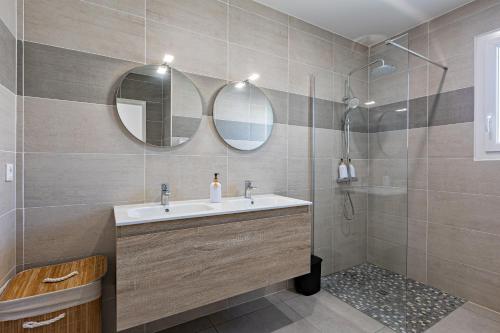 a bathroom with a sink and two mirrors at Villa Mery in Béziers