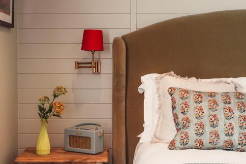 a bed with a clock on a table next to a bed at The Ropemaker - A Heartwood Inn in Emsworth
