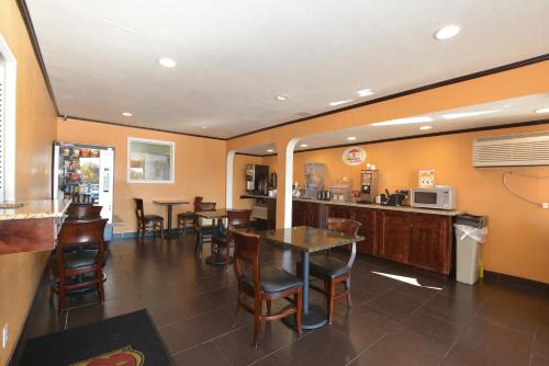 a restaurant with tables and chairs in a room at Super 8 by Wyndham Midwest City OK in Midwest City