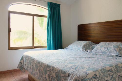 a bedroom with a bed with a large window at Casa en la playa en Club Santiago Manzanillo in Manzanillo