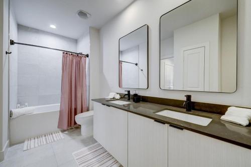 a bathroom with two sinks and a tub and a toilet at UBP - Brand New Midtown Montrose 1 Bd Apt in Houston