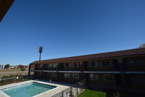 a building with a swimming pool in front of it at Super 8 by Wyndham Midwest City OK in Midwest City