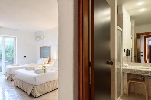 a hotel room with two beds and a bathroom at B&B HOTEL Ischia San Nicola in Ischia