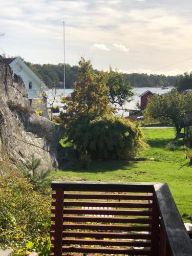 a wooden bench sitting in a field with a body of water at Guest House in Tjøme
