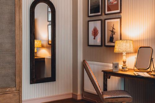 a room with a mirror and a desk with a chair at The Ropemaker - A Heartwood Inn in Emsworth