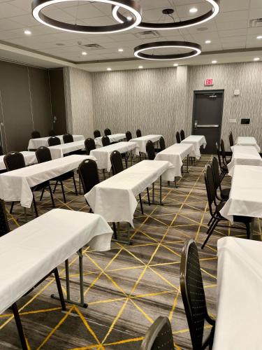 a conference room with white tables and chairs and a screen at Holiday Inn - Kalamazoo West by IHG in Kalamazoo