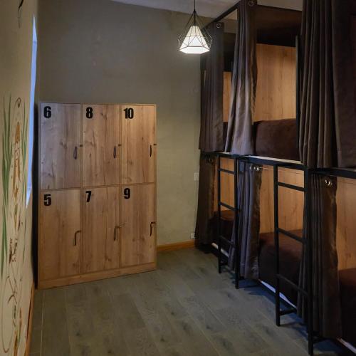a room with two bunk beds and wooden cabinets at Way Kap Hostel Cusco in Cusco