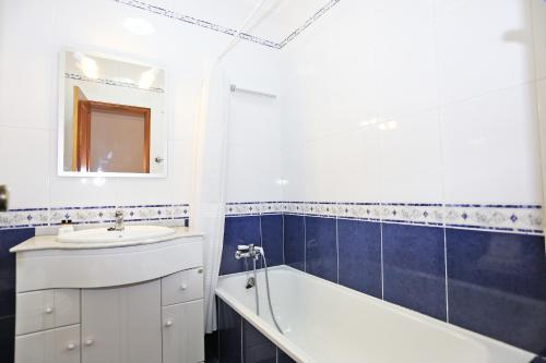 a bathroom with a sink and a bath tub and a mirror at Casas do SOL GuestHouse Lagos in Lagos