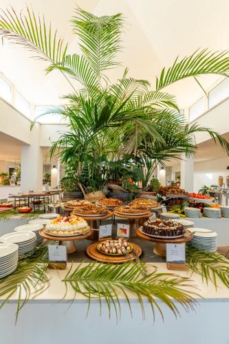 a buffet of food on display in a room with plants at Mangia's Pollina Resort in Cefalù