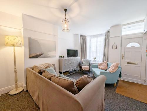 a living room with a couch and chairs and a tv at Steyne by the Sea in Bognor Regis