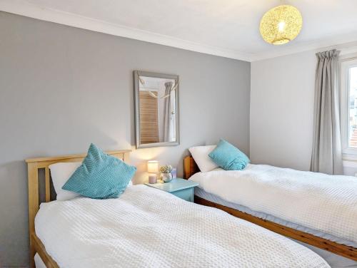 two beds in a room with blue pillows at Steyne by the Sea in Bognor Regis