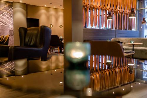 a restaurant with chairs and a table and a bar at Motel One Frankfurt Airport in Frankfurt/Main