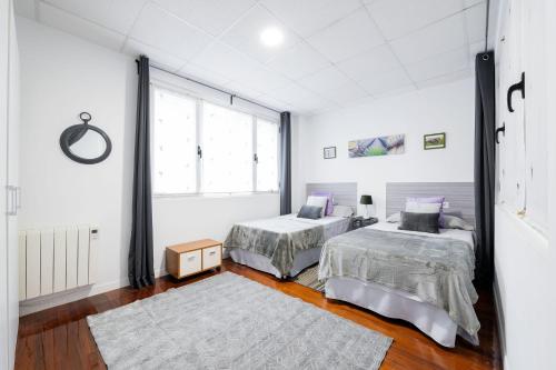 a bedroom with two beds and a window at Vivienda ideal para familias en San Sebastián in Donostia-San Sebastián