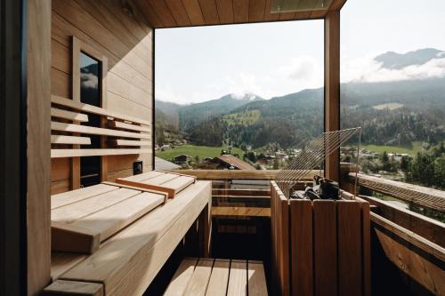 a room with a balcony with a view of the mountains at Hubertus - Das Landhaus in Kleinarl