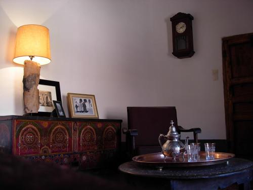 a room with a table and a clock on the wall at Kasbah Tigmi N'Oufella in Telouet