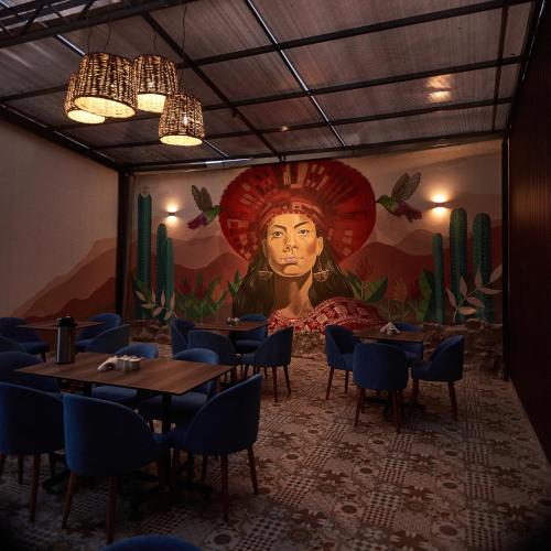 a restaurant with tables and a mural of a woman at Way Kap Hostel Cusco in Cusco