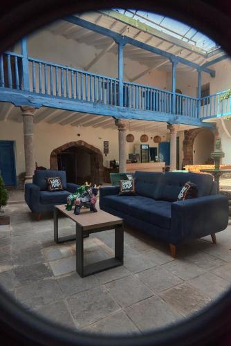 a living room with two blue couches and a table at Way Kap Hostel Cusco in Cusco