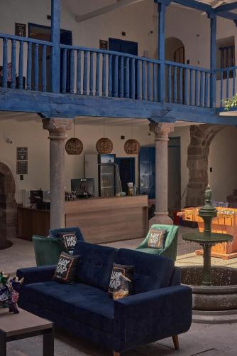 a living room with a blue couch and a staircase at Way Kap Hostel Cusco in Cusco