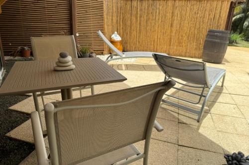 a table and two chairs on a patio at Suite Lagoon climatisée avec piscine, spa privatif in Rivière-Salée