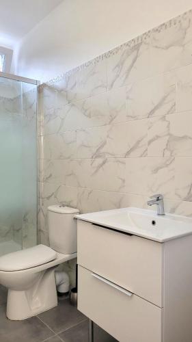 une salle de bain blanche avec des toilettes et un lavabo dans l'établissement Le Coin Zen du Vacancier, à Goussainville