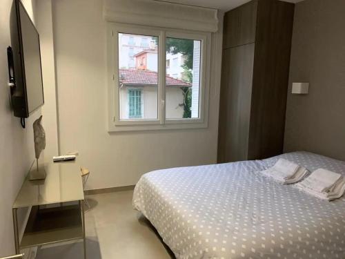 une chambre avec un lit et une fenêtre dans l'établissement Two bedroom Fragonard Cannes, à Cannes