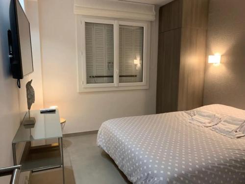 une chambre avec un lit et une fenêtre dans l'établissement Two bedroom Fragonard Cannes, à Cannes