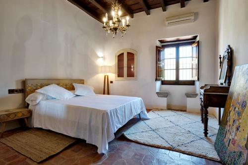 a bedroom with a white bed and a piano at La Mer Hotel in Cabrera de Mar
