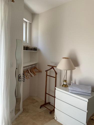 une chambre avec une commode, une lampe et un lit dans l'établissement Studio lumineux, à Villeneuve-lès-Avignon