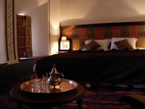 a hotel room with a bed and a table with glasses on it at Kasbah Tigmi N'Oufella in Telouet