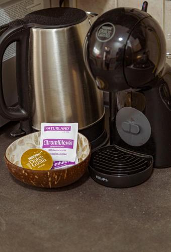 a kitchen counter with a coffee maker and a plate of food at Melissa Apartman in Balatonfüred