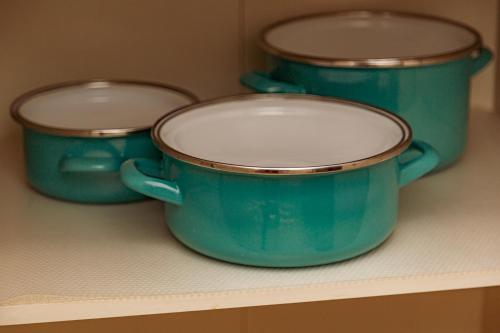three turquoise pots sitting on a shelf at Melissa Apartman in Balatonfüred