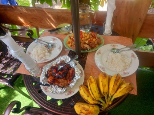 a table with plates of food and bananas on it at Hidden Tourist Inn in Abu